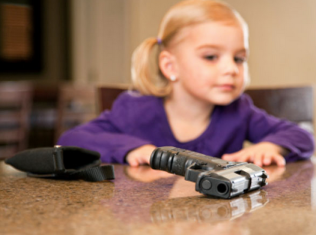 Young girl looks inquisitively at gun